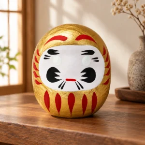 Daruma japonés dorado de papel maché, 4,5 cm en una escena ilustrativa