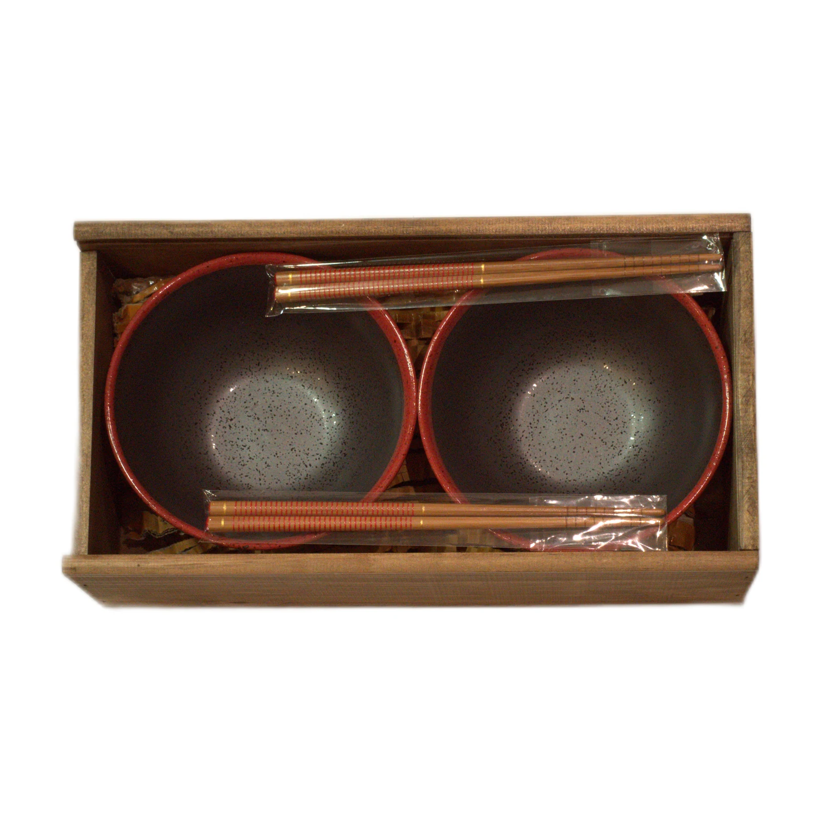 Dos cuencos con borde rojo y dos pares de palillos en caja de madera