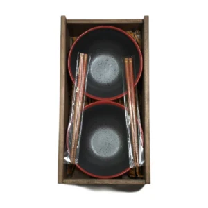 Dos cuencos con borde rojo y dos pares de palillos en caja de madera