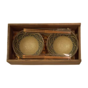 Dos cuencos con ondas azules y dos pares de palillos en caja de madera